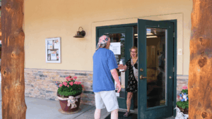 A man in a blue shirt with an American flag bandana enters MRC through the front door while a woman leaves.