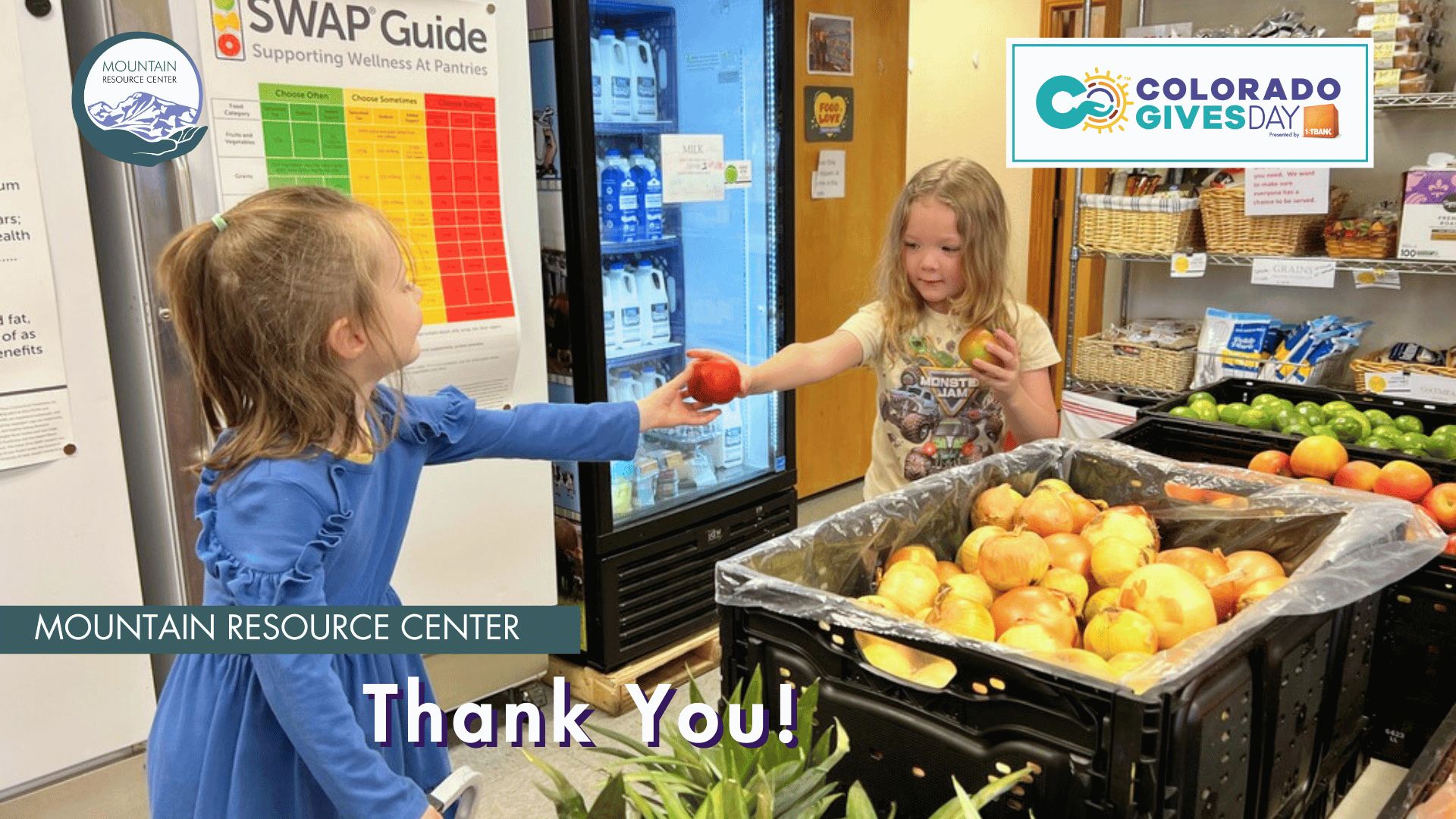 A preschool student in a blue dress hands an apple to another student in a yellow t-shirt in MRC's Food Share Market